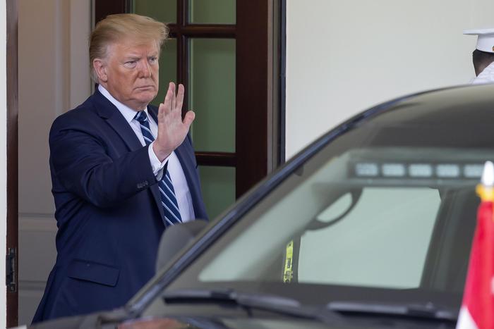 Il presidente Donald Trump con un gesto della mano respinge i giornalisti.