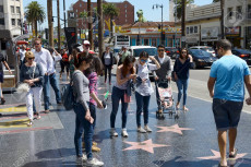 Turisti cinesi fotografando le stelle nel Boulevard di Hollywood.