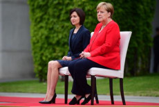 Angela Merkel ascola seduta gli inni nazionali con la Primo ministro della Moldovia Maia Sandu.