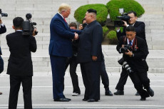 La stretta di mano tra Donald Trump e Kim Jong Un al confine tra le due Coree