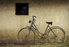 Bicicletta appoggiata al muro del negozio.