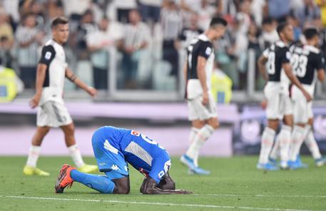 Kalidou Koulibaly in ginocchio si dispera dopo l'autogol che fa vincere la Juventus la sfida contro il Napoli.