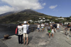 Turisti fotografano il vulcano in eruzione sull'isola di Stromboli.
