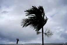 Un uomo sulla spiaggia sfida il vento dell'uragano Dorian.