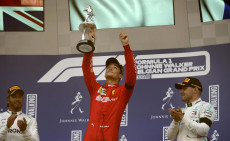 Charles Leclerc alza al cielo il trofeo del GP del Belgio vinto sul circuito di Spa a bordo della Ferrari
