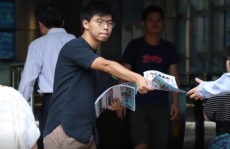 Il leader del fronte pro-democrazia Joshua Wong distribuisce volantini nella strada. Immagine d¿archivio.