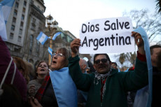 Manifestanti con il cartello "Dio salvi l'Argentina".
