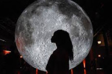 L'ombra di una donna ritagliata sull'immaggine della luna al fondo.