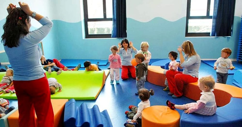 Un' insegnante gioca con i bambini in un asilo nido