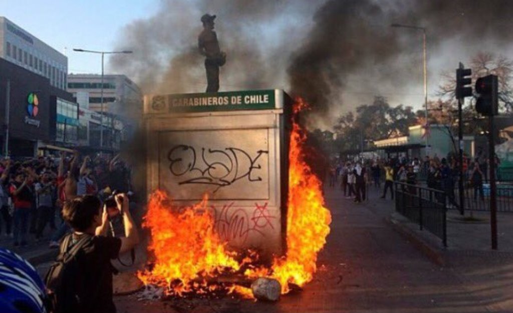 Durante le proteste manifestanti appiccano fuoco a una statua dei Carabineros di Cile.