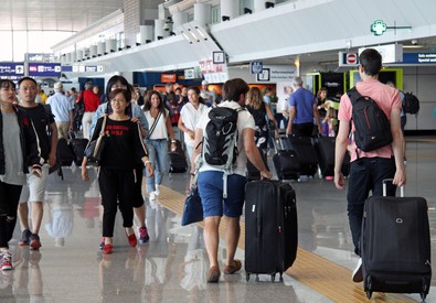Giovani trascinando valige in aeroporto
