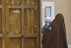 La donna di origine marocchina con il niqab, uno dei tradizionali abiti indossati da chi professa la religione islamica, mentre accompagna il figlioletto alla scuola materna di Sonnino (Latina).