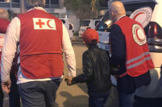 In questa foto Alvin, un bambino di 11 anni, accompagnato da funzionari della Croce Rossa, riscattato da un campo profughi in Siria.