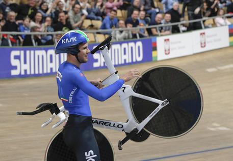 Filippo Ganna, solleva sua bici felice dopo l'oro mondiale.