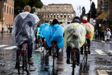 Turisti si riparano dalla pioggia in via dei Fori Imperiali, Roma
