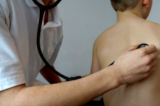 Medico ausculta polmoni di un bambino.