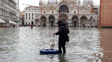 Un uomo passeggia con il cane su un salvagente a Venezia,