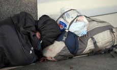 Un senzatetto addormentato in una strada del centro di Milano.