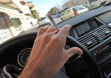 La mano con una sigaretta mentre sta al volante.