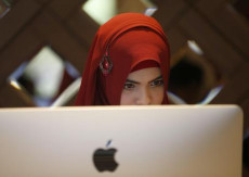 Una ragazza musulmana lavora con un computer Apple.