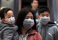 Una famiglia cinese con la mascherina per evitare il contagio del virus.