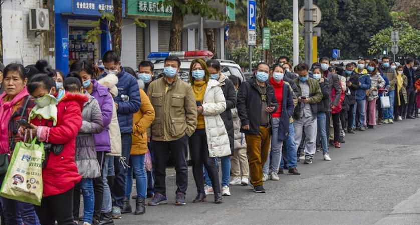 Persone in fila con le mascherine in Cina