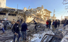 Cittadini osservano i danni di un attacco del Ejército sirio al mercato di Binnish, nella provincia di Idlib. Immagine d'archivio.