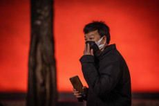 Un uomo con la mascherina protettiva sul ponte di Tiananmen in Beijing.