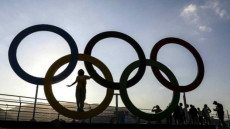 Una scultura con i cerchi del logo delle Olimpíadi all'ombra.