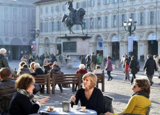 Clima primaverile con 25∞ gradi a Torino, seduti al tavolo di un bar in piazza.