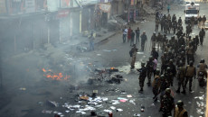 Una squadra delle forze di sicurezza indiane pattuglia una strada divenuta escenario di scontri violenti tra fazioni politiche rivali a New Delhi.