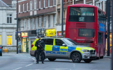 Un polizziotto armato assicura il luogo dove venne abbattuto il terrorista che ferí con il coltello a passanti nella strada a Streatham, Londra.