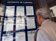 Un uomo controlla gli annunci di lavoro esposti in una agenzia per l'occupazione a Pisa.