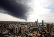 Una nuvola di fumo riempie il cielo di Tripoli dopo un attacco con razzi lanciato da miliziani di una delle fazzioni in lotta nel paese.