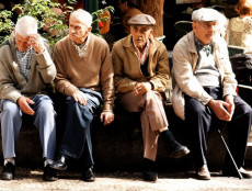 Alcuni pensionari seduti in una panchina.