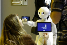 Una donna guarda un robot durante il Congresso Mondiale Digital Bussines a Madrid