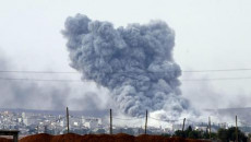 Una veduta dal territorio turco mostra una nuvola di fumo che s'innalza dopo che il fuoco dell' artiglieria colpisce Kobane,Siria.