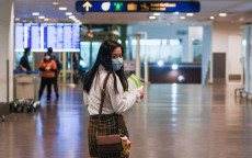 Una giovane con mascherina nell'aeroporto di Wuhan.