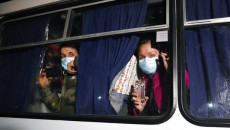 Passeggeri ucraniani a bordo di un autobus si dirigono in un centro medico a Novi Sanzhary per un periodo di quarantena.