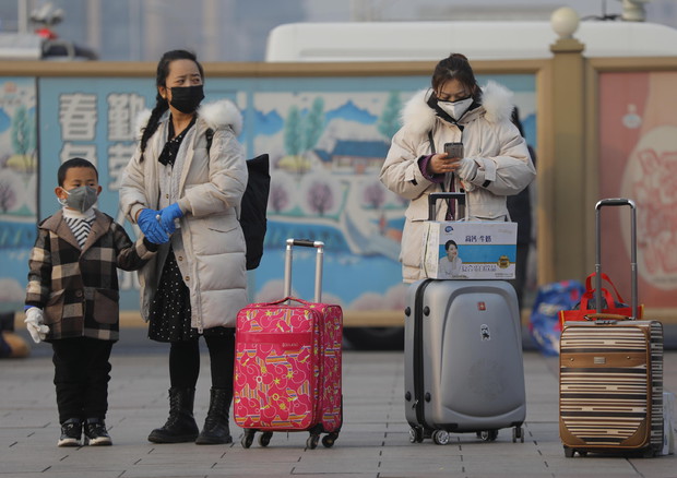 Viaggiatori cinesi indossano le mascherine