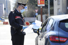 Un Carabiniere controlla l'autocertificazione di cittadino a Corsico, vicino Milano.