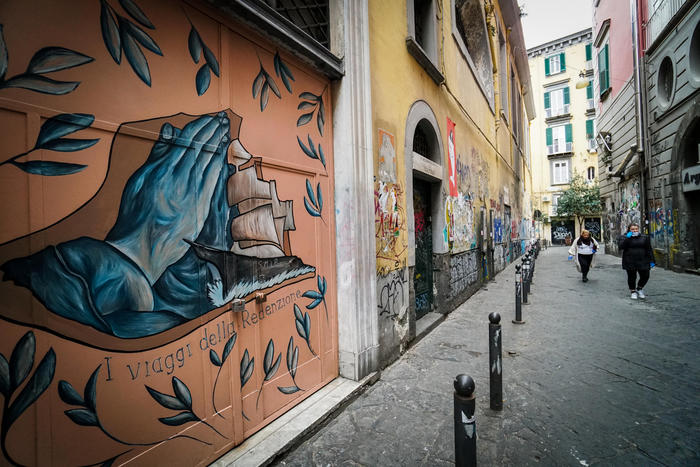 Coronavirus in Italia: un murale su una via deserta di Napoli..
