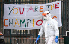 Medico di fronte all'ospedale di Genova con un graffiti "You are the champions".