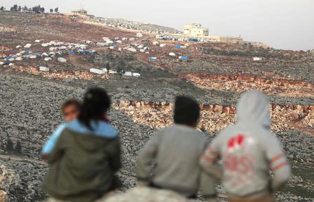 Bimbi siriani guardano la cittá di Idlib al confine con la Turchia.