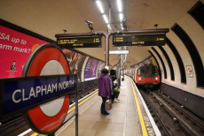 Pochi viaggianti aspettano nella piattaforma della metropolitana di Londra alla stazione di Clapham Common.