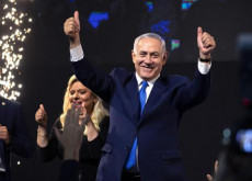 Il primo ministro d'Israele Benjamin Netanyahu (D) e sua moglie Sarah (S) fanno il segno della vittoria con i pollici alzati