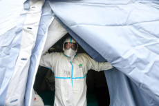 Un medico esce da una tenda allestita per assistere i contagiati di coronavirus a Brescia..