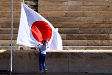La bandiera del Giappone durante la ceremonia ad Atene per la partenza della fiamma olimpica per Tokyo.