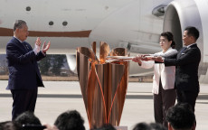Il campione olimpico di judo Tadahiro Nomura (D) e la campionessa olimpica di lotta Saori Yoshida (2-D) accendono la fiamma olimpica in un calderone durante la ceremonia di accoglienza alla base aerea Matsushima Air Base a Higashimatsushima, Giappone.ARCHIVIO