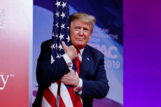 Il presidente Donald Trump abbraccia la bandiera degli Stati Uniti, in un'immagine d'archivio.